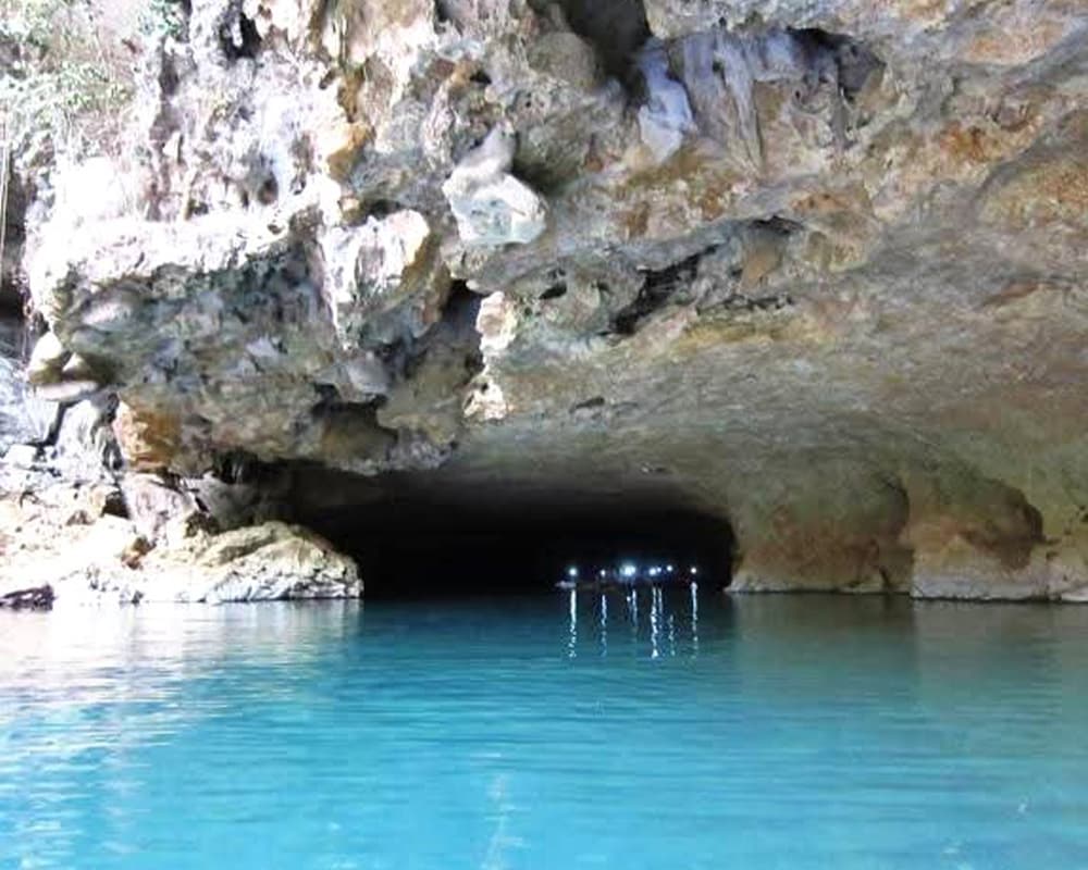 A serene blue water cave with a rocky entrance.